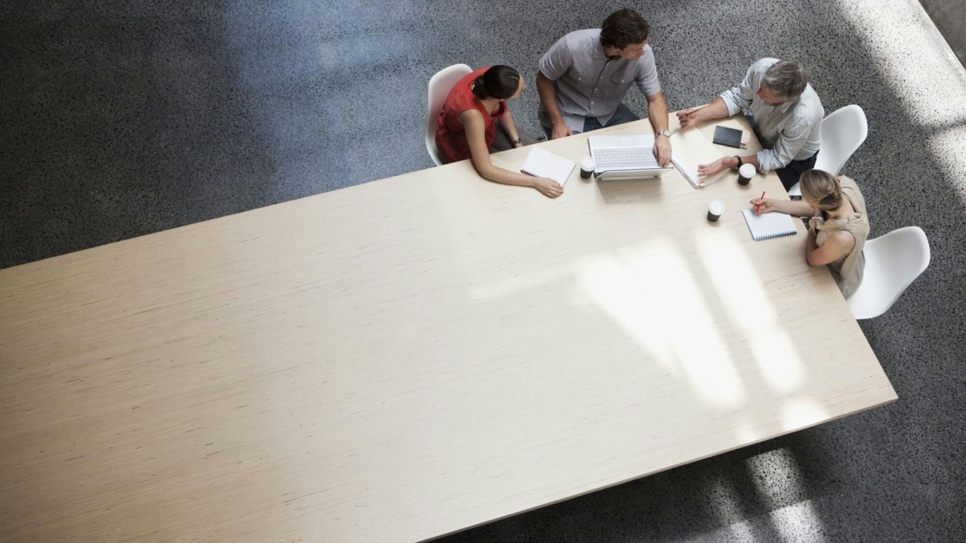 Grosser Holztisch mit 4 Personen in einem Meeting